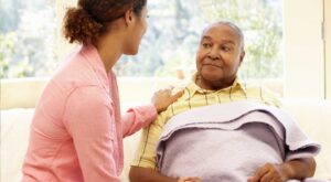 young-black-female-providing-care-for-elderly-black-male